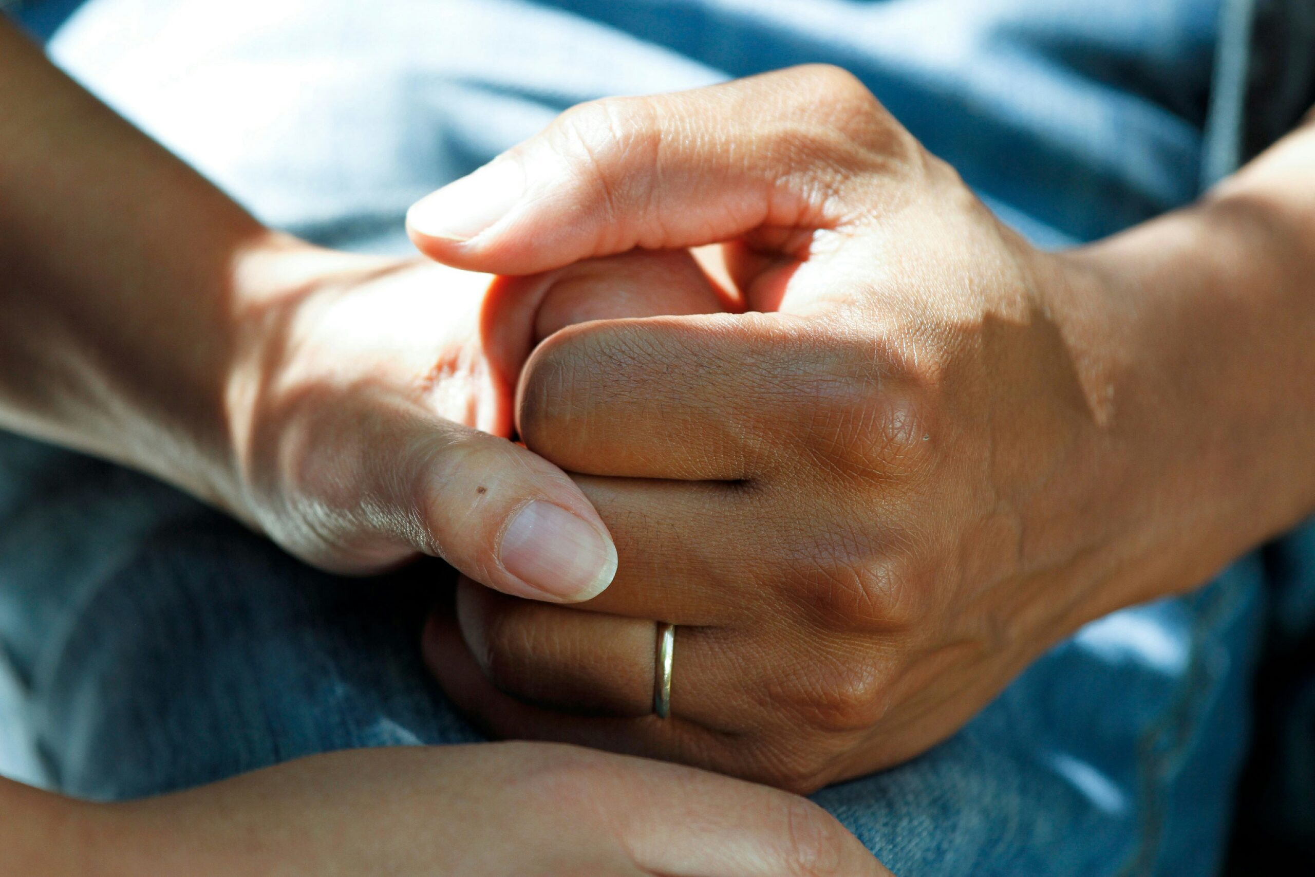 two hands holding with light shining in the background