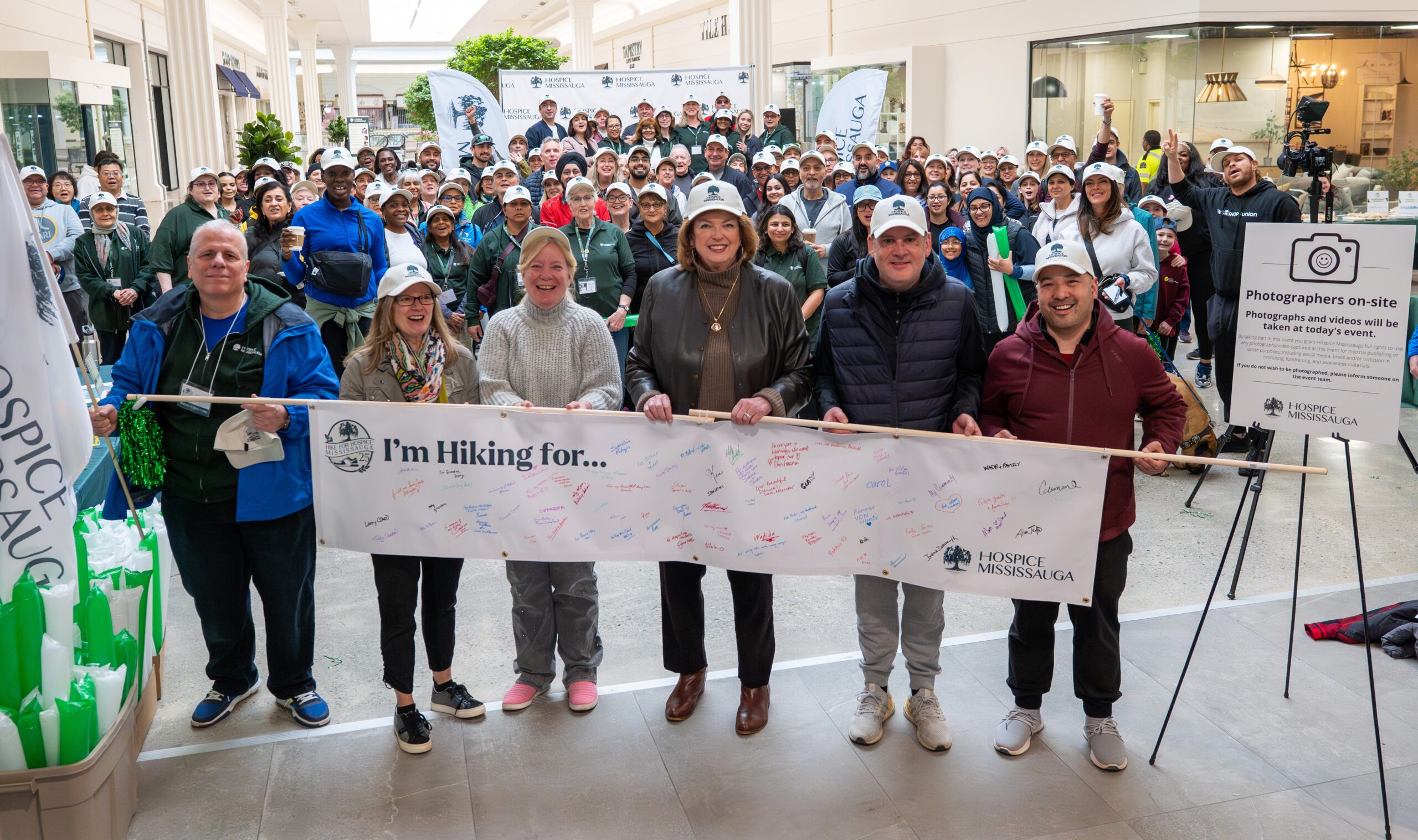 Group of people standing with a banner that says Hike for Hospice in a mall