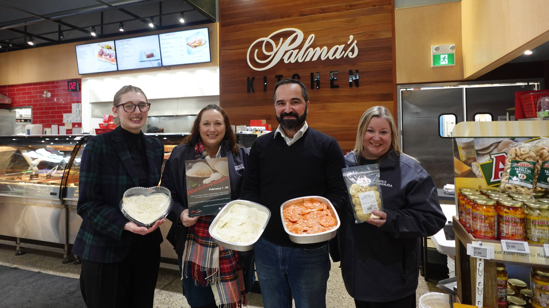 Group of four people standing with Palma Pasta Hearts for Hospice pasta